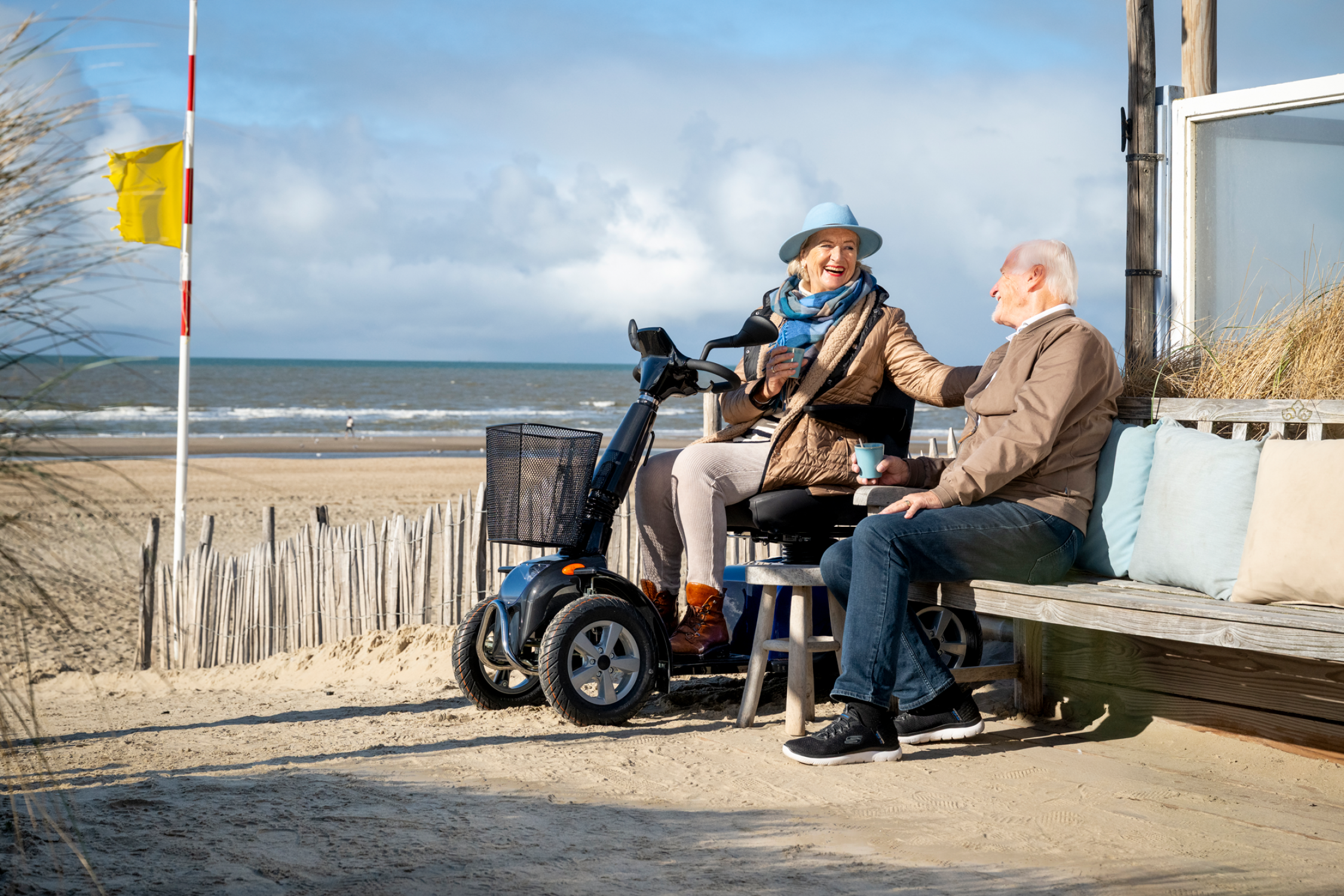 Een koppel op een terras aan zee met de Solo RX 4-wiel scootmobiel